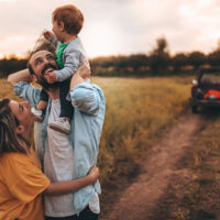 Photo of young family spending some quality time together outdoors in nature, with their baby boy